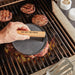 Cast Iron Meat Press for Smash Burgers — in use on hot grill pressing smash burgers with Hot Off The Press wood handle