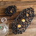Cast iron tea light candle warmer stands with scroll detailing styled on wooden surface with teapot