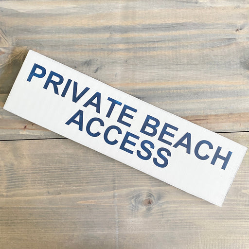 Rectangular sign with 'PRIVATE BEACH ACCESS' text on a wooden surface