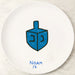 White plate with a blue dreidel and 'NOAM 14' text on a marble surface