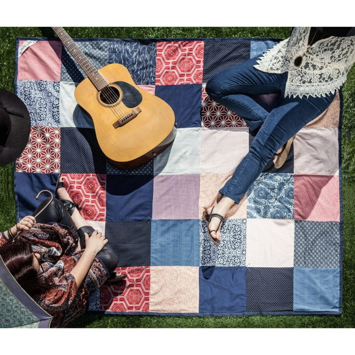 Festival Blanket — patchwork quilt laid out on grass with people and guitar, festival lifestyle shot