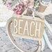 Mini jute beach tote bag with BEACH lettering, leather handles, and waterproof lining styled on a bicycle