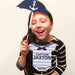 Girl holding navy nautical baby shower photo booth props including anchor umbrella and Captain onesie sign