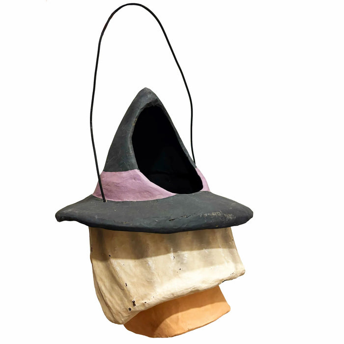 A whimsical, handcrafted papier-mâché witch bucket with a black wire handle. 