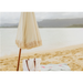 Beige beach umbrella and towel on a sandy beach with ocean in the background