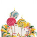 Set of 3 swirly lollipop birthday candles in pink, blue, and yellow on a decorated birthday cake