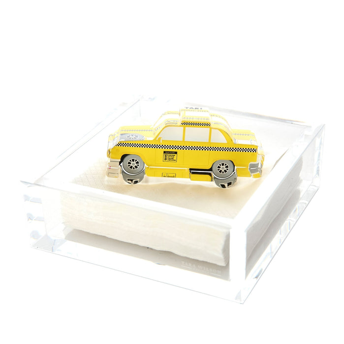 Clear acrylic cocktail napkin holder with yellow New York City taxi cab weight and white napkins
