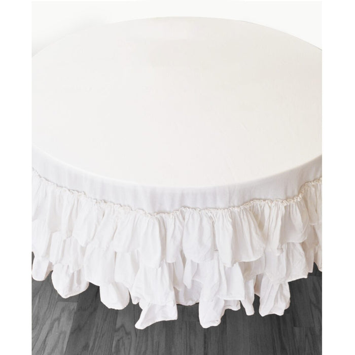 White triple ruffle round tablecloth draped over round table, top angle view
