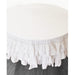 White triple ruffle round tablecloth draped over round table, top angle view