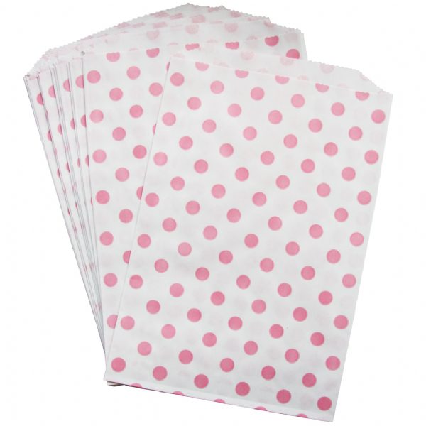A set of white paper treat bags with pink polka dots.